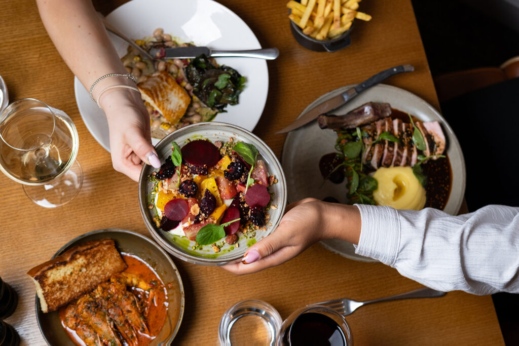 People are enjoying their meal and sharing a plate of starters.